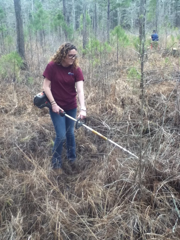 A young woman (student) using land management equipment.