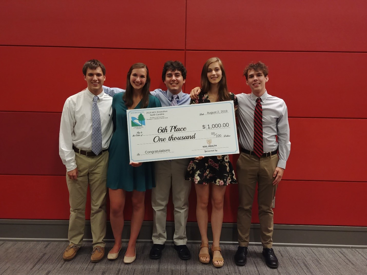 Spartanburg high school students holding check for $1000.