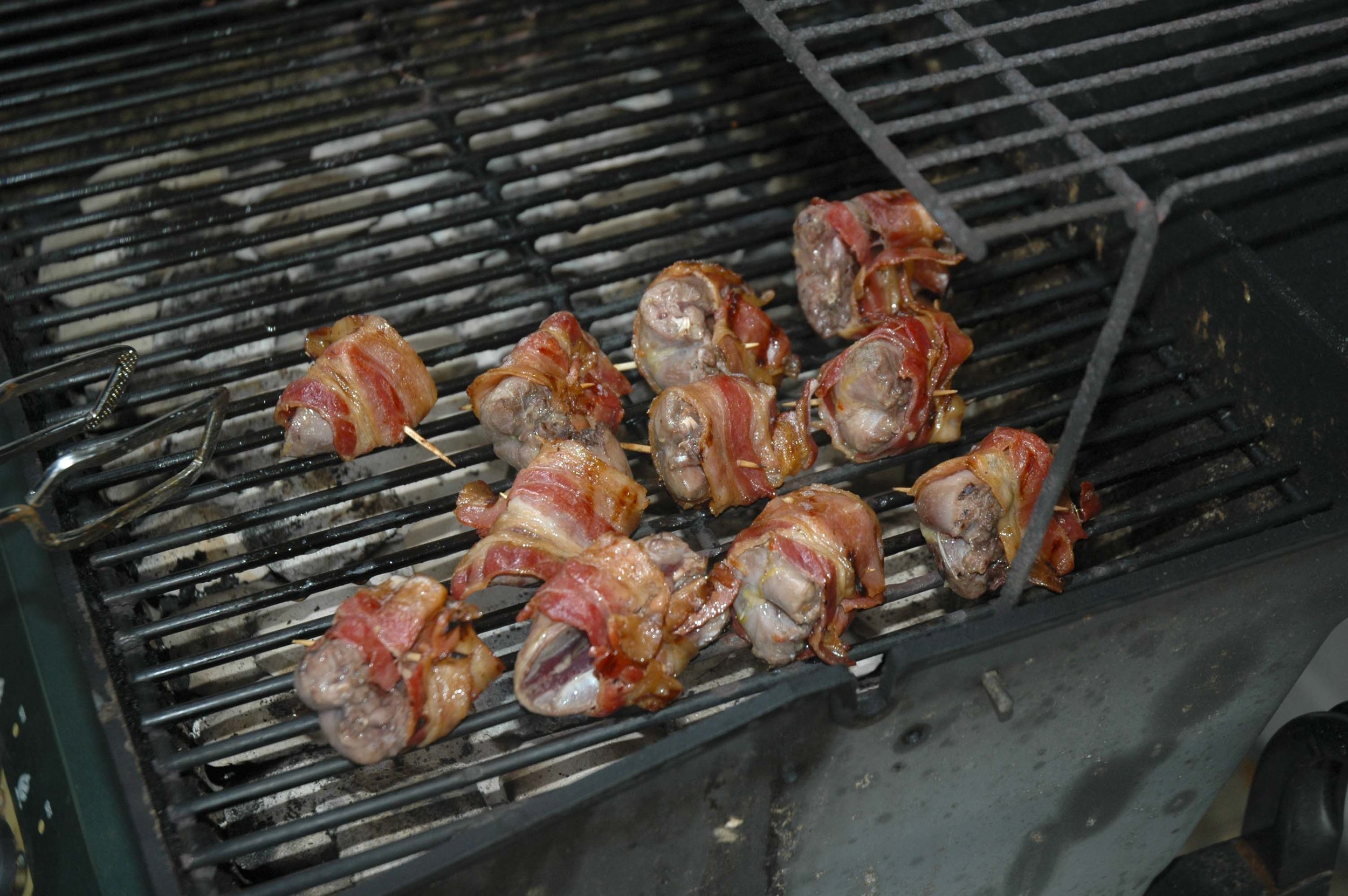 Dove breasts wrapped in bacon cook slowly on a grill. photo by Phillip Jones